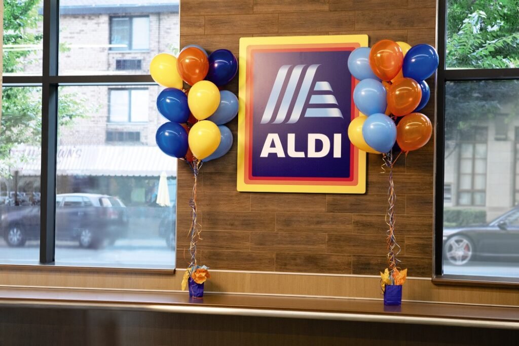 ALDI logo sign surrounded by colorful balloons inside an existing store