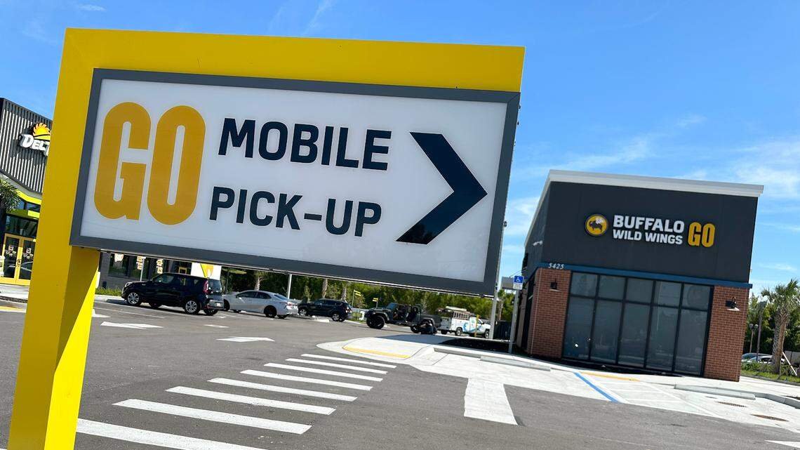 Buffalo Wild Wings GO restaurant with a mobile pickup directional sign