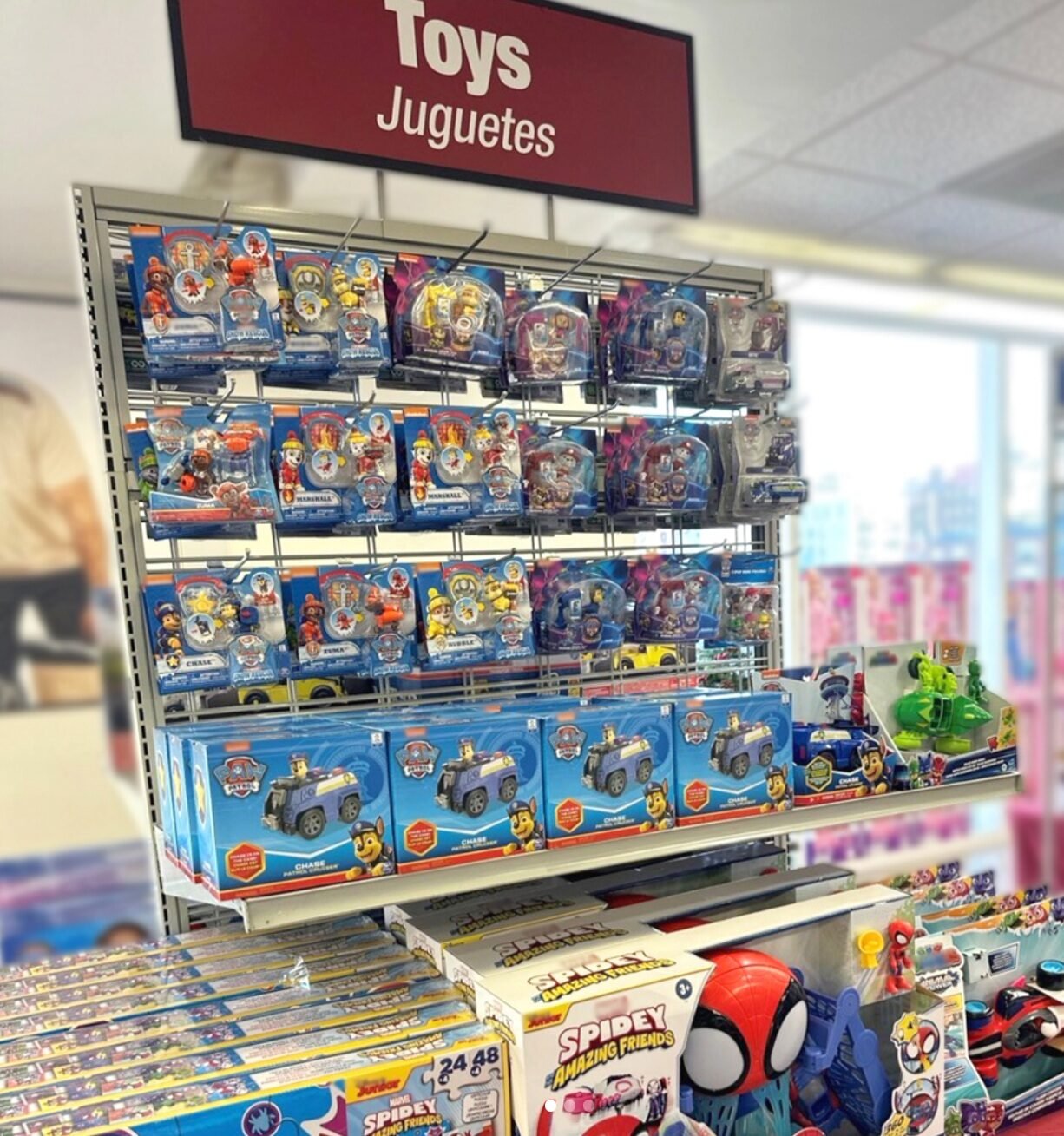Burlington toy department with shelves of packaged character toys beneath a Toys sign.