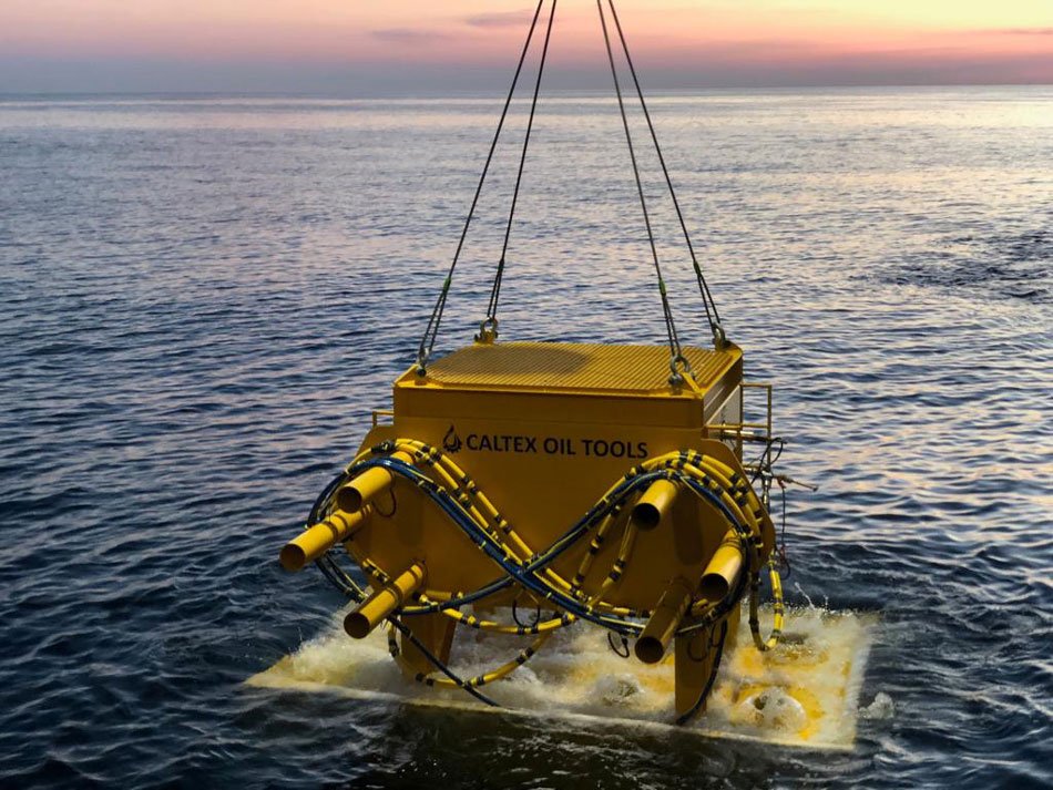 Caltex Oil Tools Offshore Equipment Yellow Caltex Oil Tools equipment suspended by lifting cables at the ocean surface
