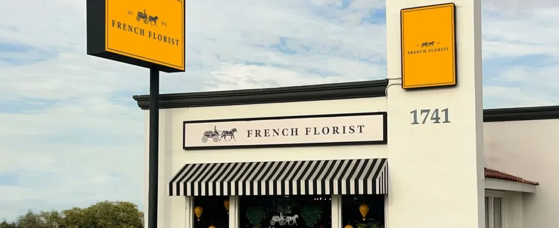 FrenchFloristStorefront French Florist storefront with yellow signs and a striped awning