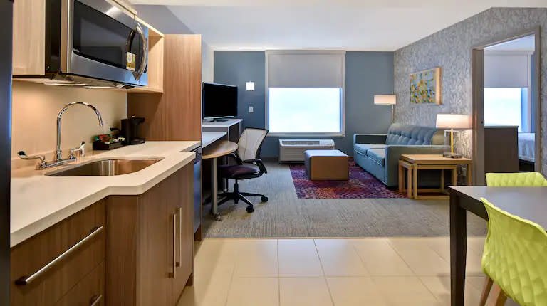 Home2 Suites Kitchen and Living Area Home2 Suites interior with a kitchenette, desk, sofa, and separate living space.