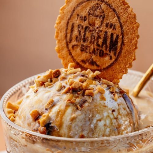 I Scream Gelato dessert topped with chopped nuts, sauce, and a branded wafer