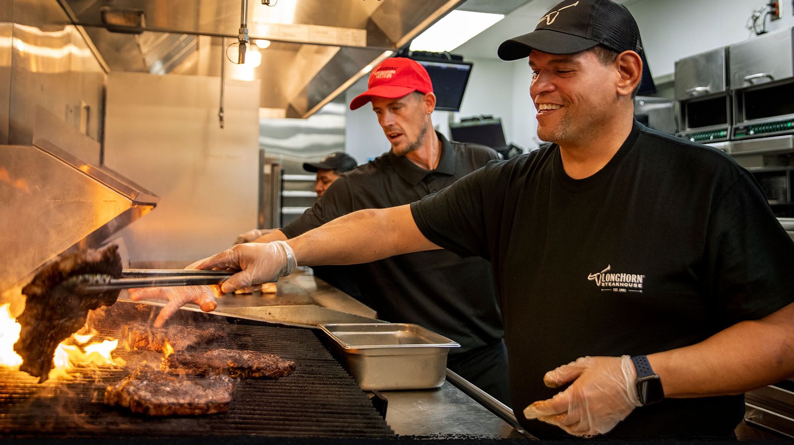 LongHorn Steakhouse grill team preparing steaks over flames