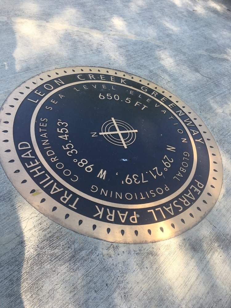 Circular Leon Creek Greenway marker identifying the Pearsall Park trailhead.