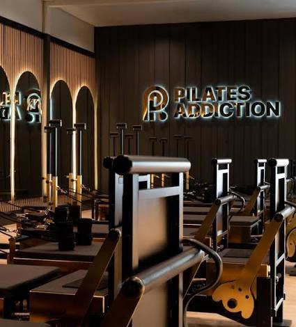 Gold-toned reformers inside a Pilates Addiction studio