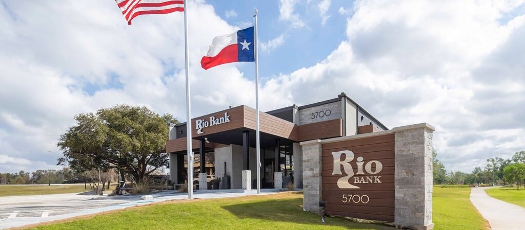 Representative Rio Bank exterior with drive-through canopy and flags; not the Rio Bank Jackson project