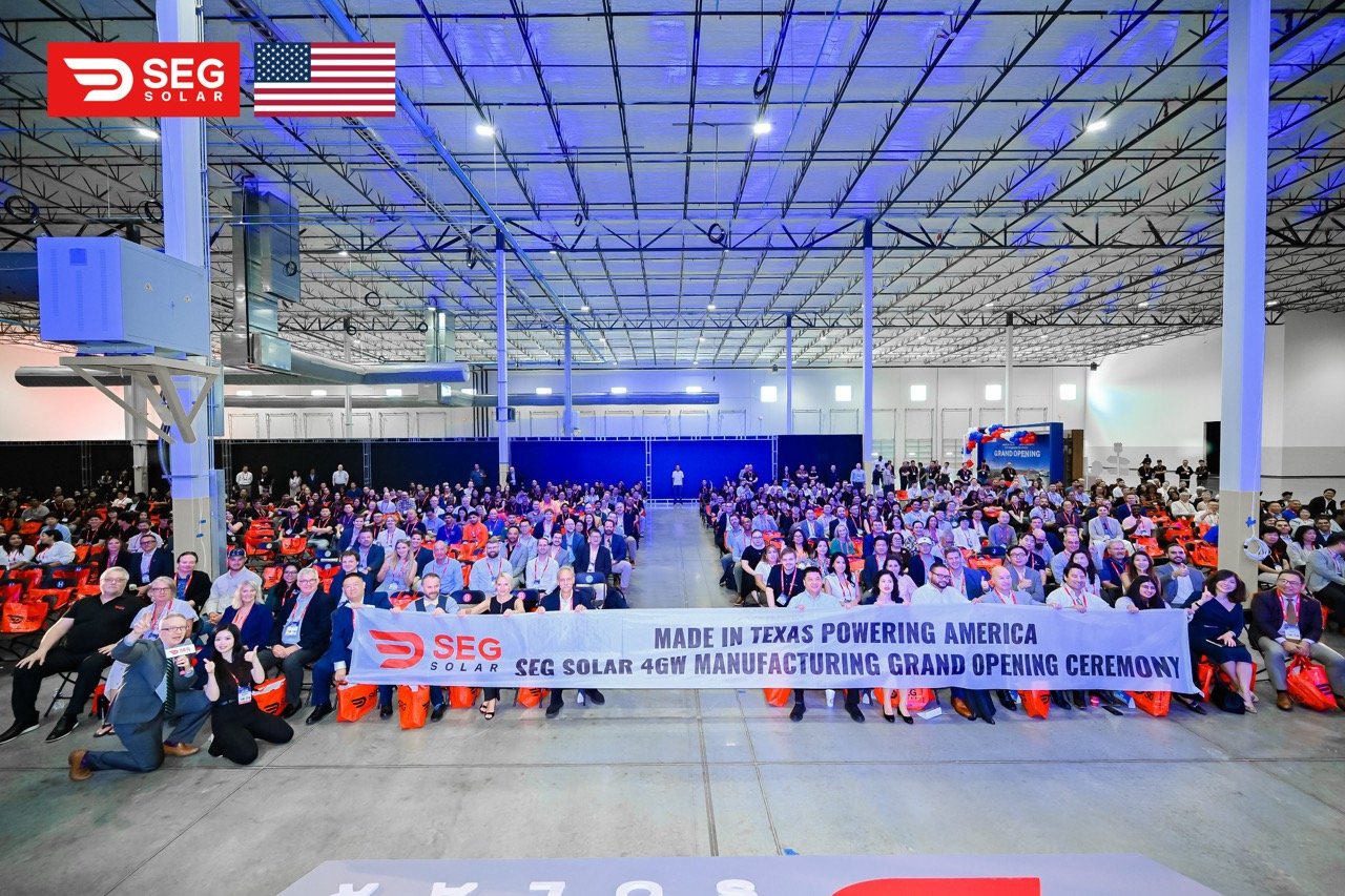 SEG SOLAR Grand-opening attendees gather inside SEG Solar's Tomball #1 factory behind a manufacturing ceremony banner