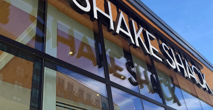 Shake Shack Storefront Shake Shack storefront with white lettering, a green burger logo, and glass windows.