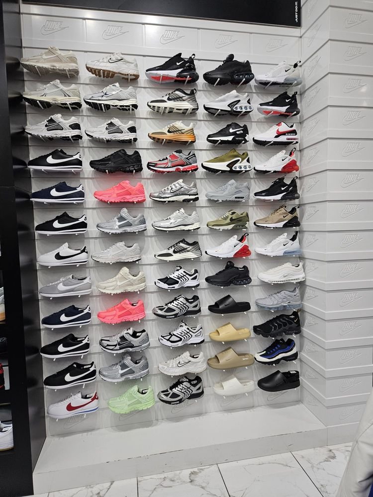 Nike sneakers and slides arranged on a Shoe Palace display wall