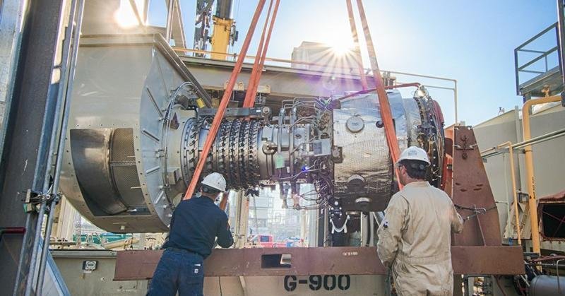 Solar Turbines Service Technicians Technicians guide a suspended turbine during Solar Turbines service work