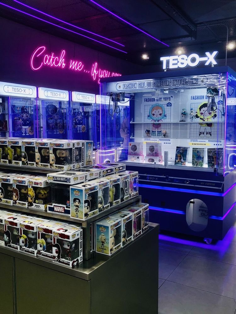 Collectible figures and claw machines at an existing store, representative of the TESO X Hurst brand