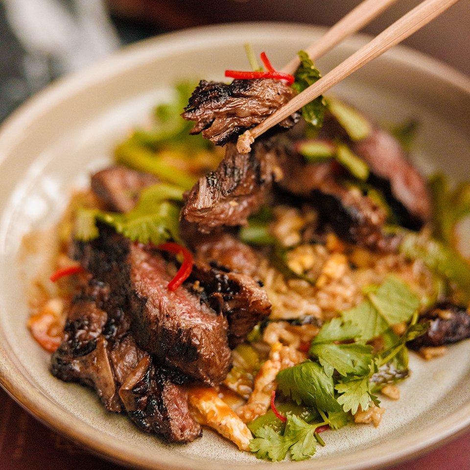 The Henry Grilled Meat and Rice Sliced grilled meat over rice with fresh herbs at The Henry.