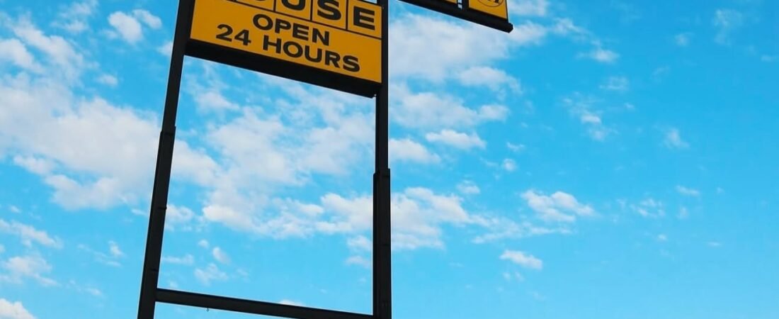Waffle House restaurant exterior with a yellow roadside sign and red awnings