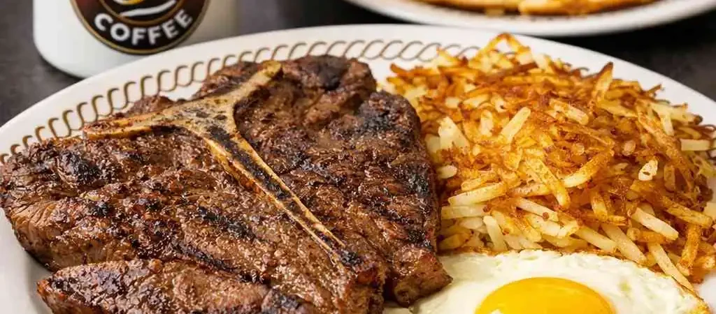 Waffle House Breakfast Spread Waffle House breakfast with steak, eggs, hash browns, a waffle, and coffee.