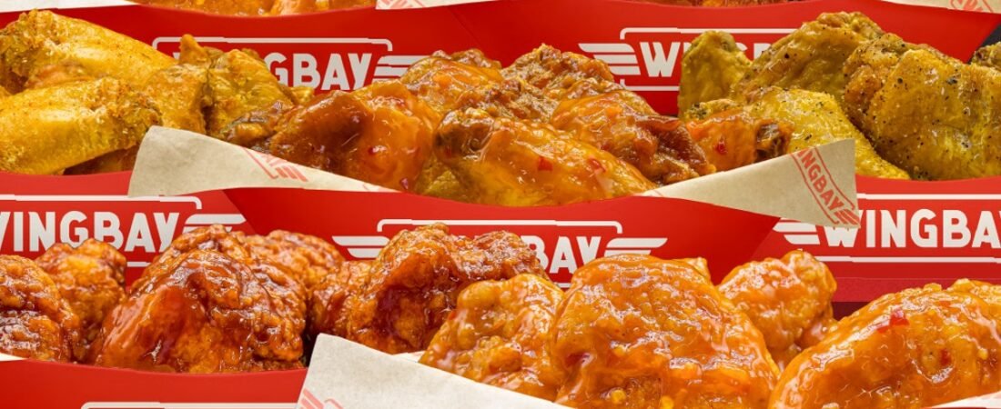 Sauced and seasoned chicken wings in red Wingbay trays.