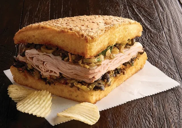 Jason's Deli Muffaletta Sandwich Jason's Deli muffaletta sandwich with sliced deli meat, olive mix, and potato chips.