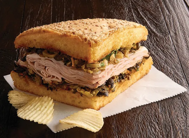 Jason's Deli muffaletta sandwich with sliced deli meat, olive mix, and potato chips.