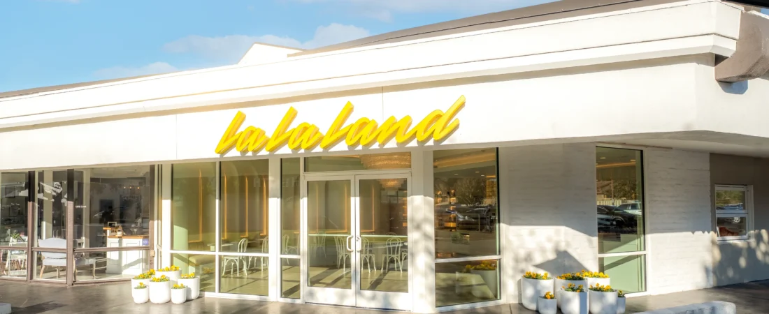 lalalandexterior Representative La La Land storefront with yellow signage for the La La Land Cafe Cypress expansion story
