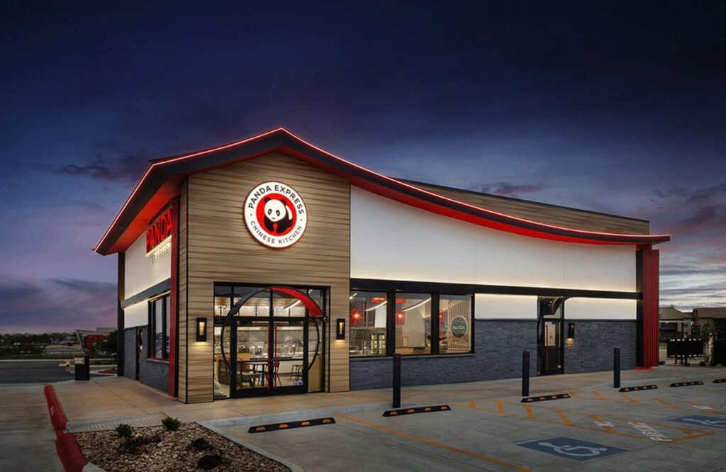 Panda Express restaurant exterior with illuminated red trim at dusk.