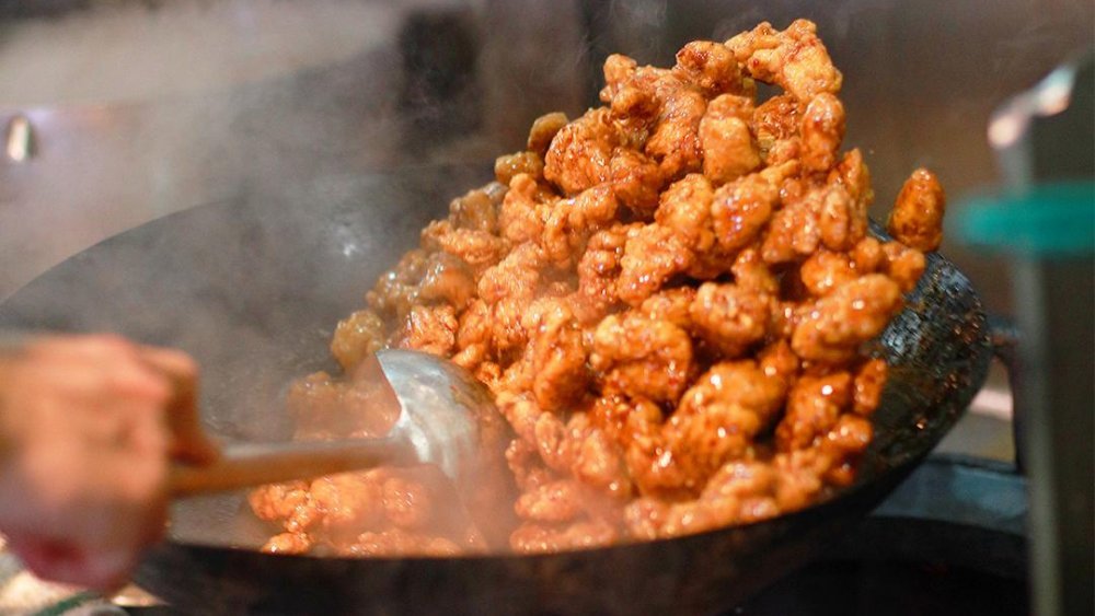 Panda Express Orange Chicken in the Wok Panda Express orange chicken tossed in a steaming wok.