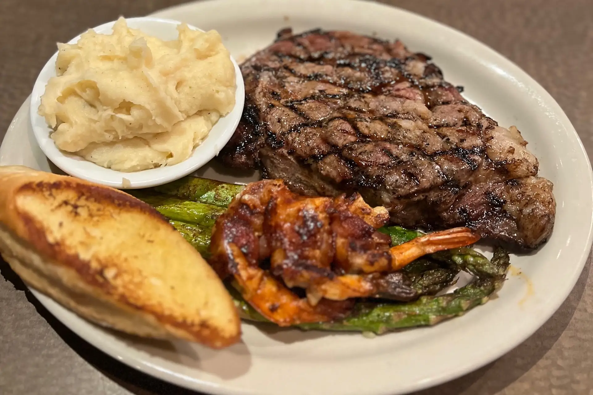 Grilled steak and shrimp with mashed potatoes, asparagus, and toast at Pier 36.
