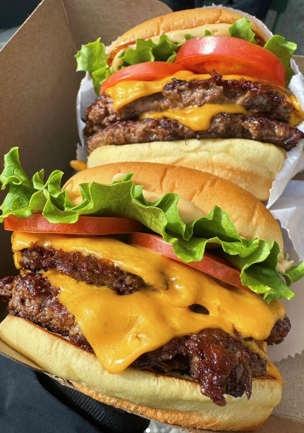 Shake Shack Burgers Two Shake Shack cheeseburgers with lettuce and tomato
