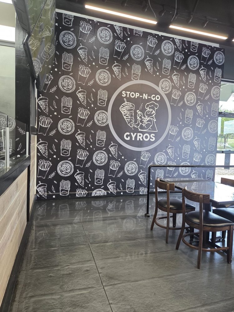 Stop N Go Gyros logo wall and dining tables — representative interior for the Stop N Go Gyro San Antonio expansion story