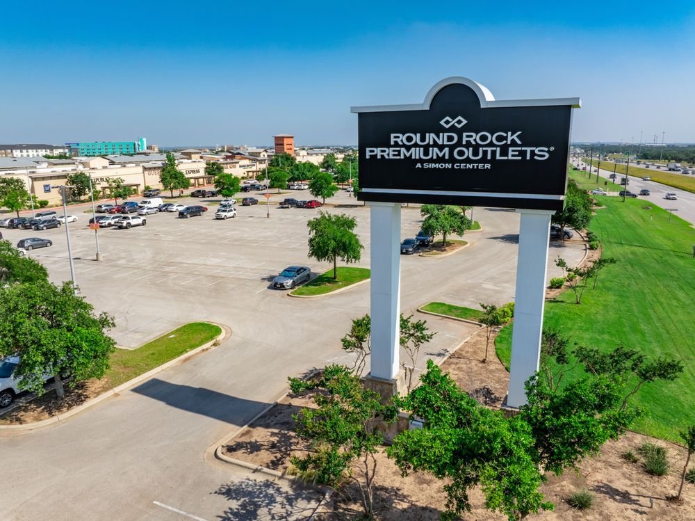 Round Rock Premium Outlets Round Rock Premium Outlets entrance sign beside the shopping center and parking lot